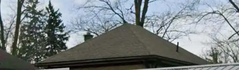House with asphalt shingle roof, bare trees, and partly cloudy sky in Milverton, Ontario.