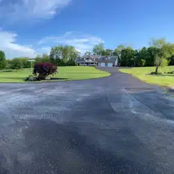 New Project (11) Large house with new roof, long driveway, and green lawn under clear blue sky.
