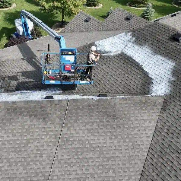 New Project (26) Worker on a lift power washing roof shingles for asphalt rejuvenation.