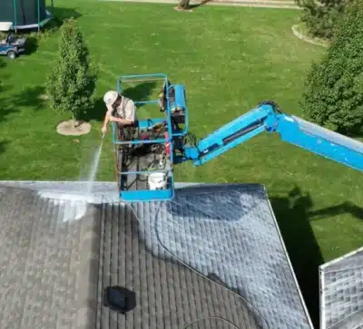 Image_-400×363 Person on blue lift pressure washing house roof.