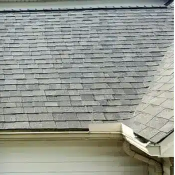 Gray asphalt shingle roof with rain gutter.