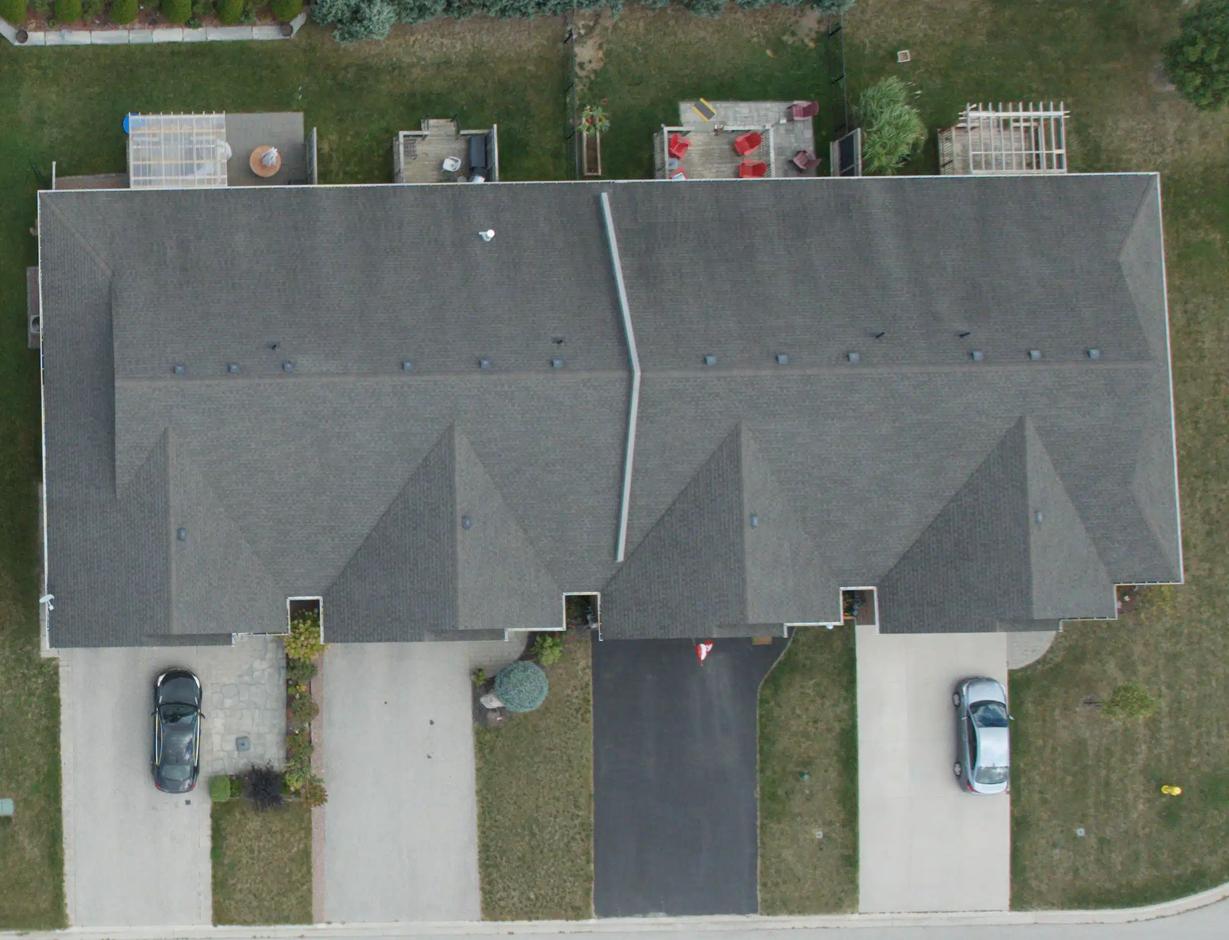 New Project (9) Aerial view of Victoria BC duplex with two driveways, parked cars, and backyard patios.