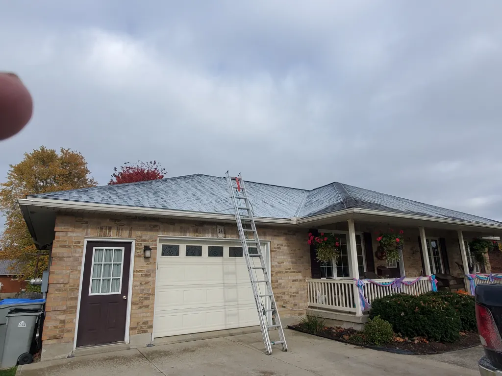 Tall ladder leaning against roof for Preventative Reactiv8 shingle rejuvenation service.