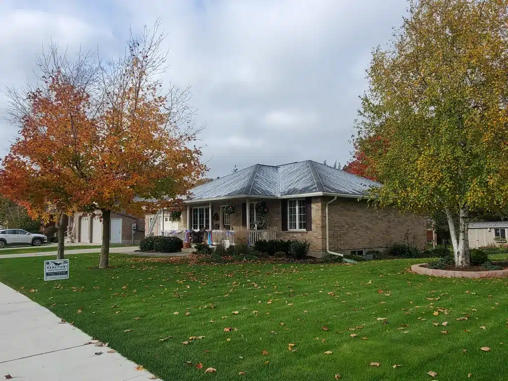 Milverton bungalow with autumn trees, green lawn, and For Sale sign on front yard.