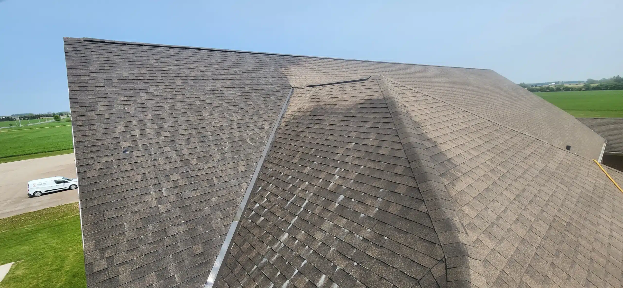 Shingle roof in Donegal, Ontario with a noticeable clean patch contrasting dirty shingles.