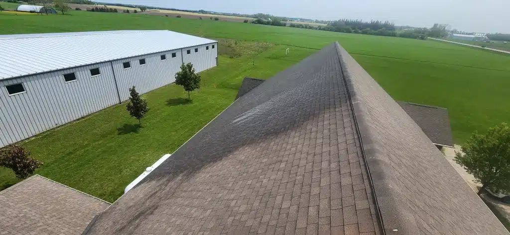 Church roof with missing shingles, nearby fields, and metal building in Donegal, Ontario.