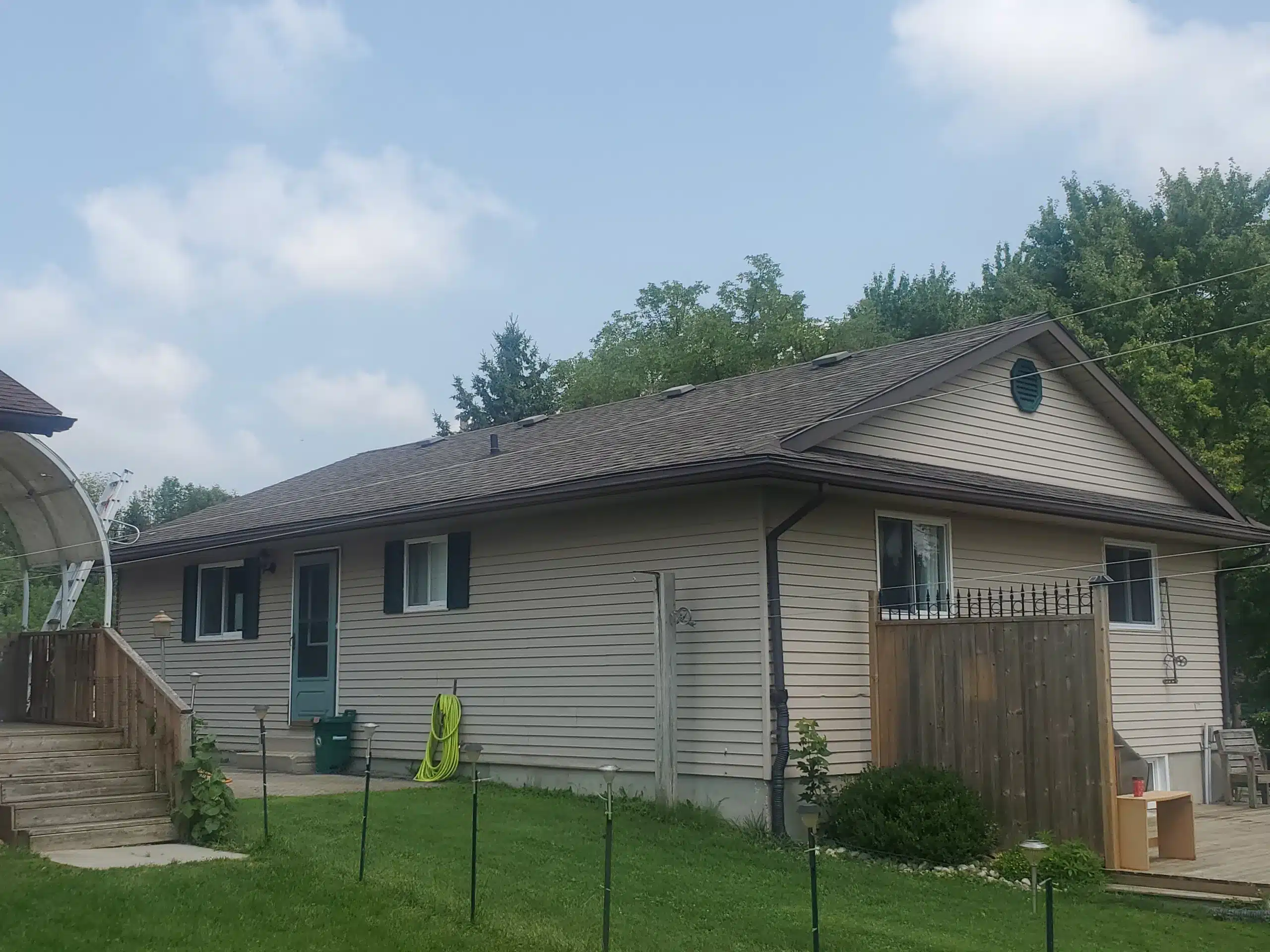 Beige single-story house in Palmerston, Ontario with fenced yard, green lawn, asphalt shingle roof.